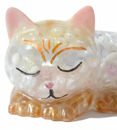 Closeup of face of Handcrafted sleeping cat resin figurine filled with white iridescent pearls and amber translucent accents by Crazy Chaotic Crafter